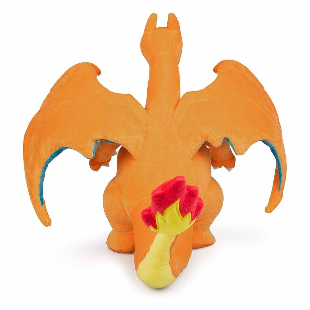 Ein kleines orangefarbenes Charizard-Plüschtier, von hinten gezeigt, mit ausgebreiteten Flügeln und einer rot-gelben Flamme auf seinem Schwanz vor weißem Hintergrund.