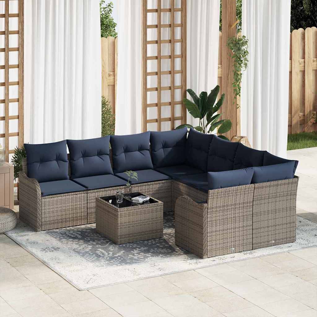 Outdoor-Rattanecksofa mit marineblauen Kissen, passendem Couchtisch und Teppich auf einer Terrasse unter weißen Vorhängen.