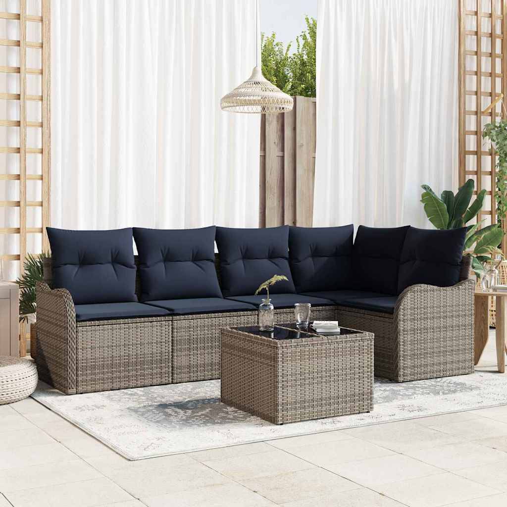 Gartenmöbel-Set für die Terrasse mit dunklem gepolstertem Rattan-Ecksofa, passendem Couchtisch und Teppich in einem hellen, modernen Raum.