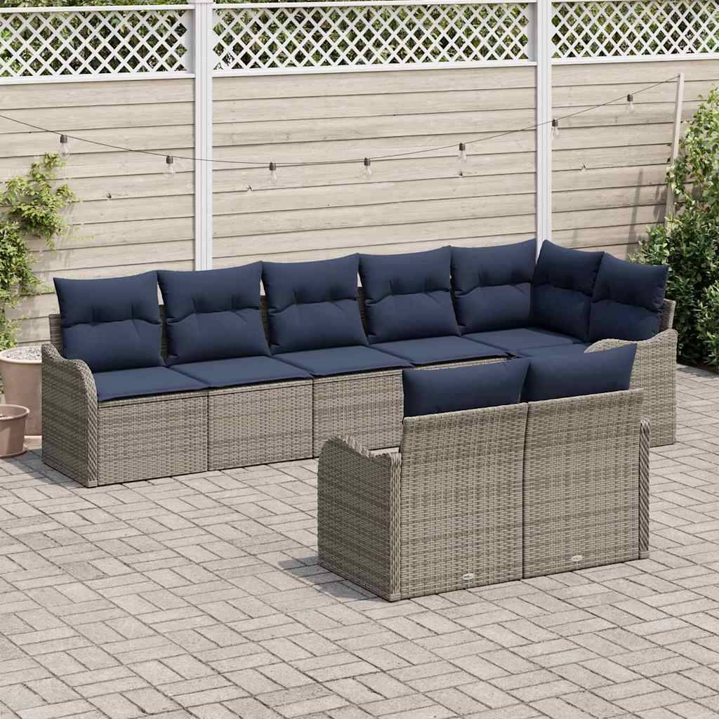 Gartenpolster-Set mit grauem Rattan-Loungemöbel, marineblauen Kissen, passendem Sessel und Beistelltisch auf einer gepflasterten Terrasse im Hinterhof.