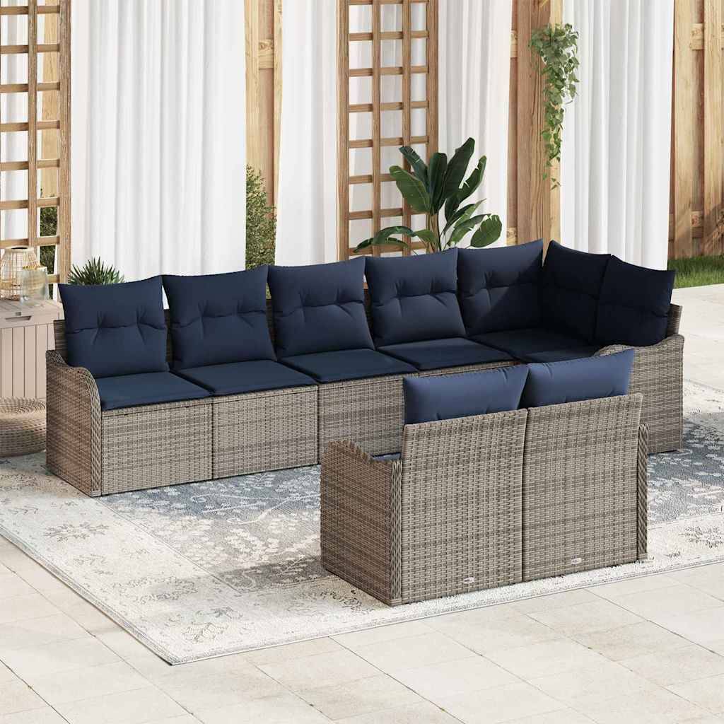 Outdoor-Rattansofa-Set mit dunkelblauem Kissen, angeordnet um einen niedrigen Couchtisch auf einem Terrasserteppich.