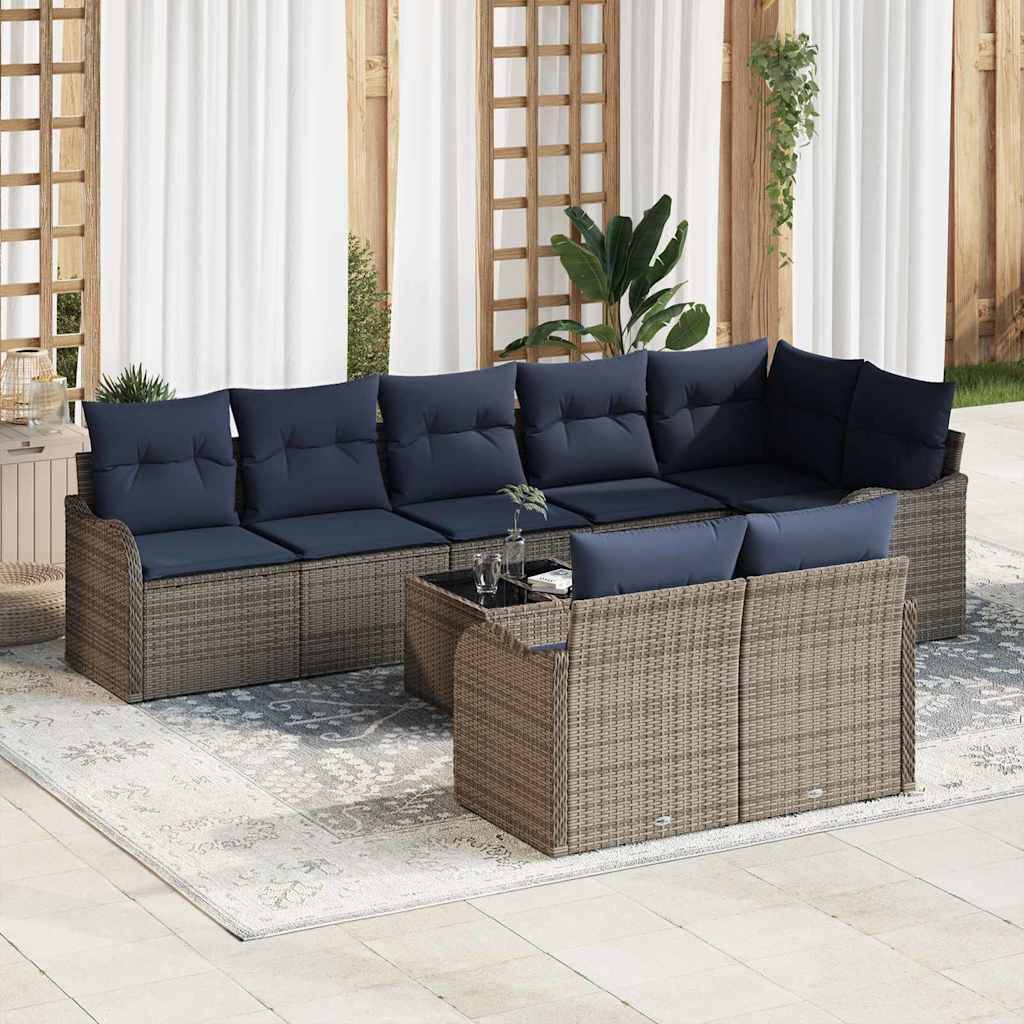 Outdoor-Rattanpolster-Gartensektion mit marineblauen Kissen und passendem Ottomane auf einem hellen Teppich in einer hellen, überdachten Patiobereich.