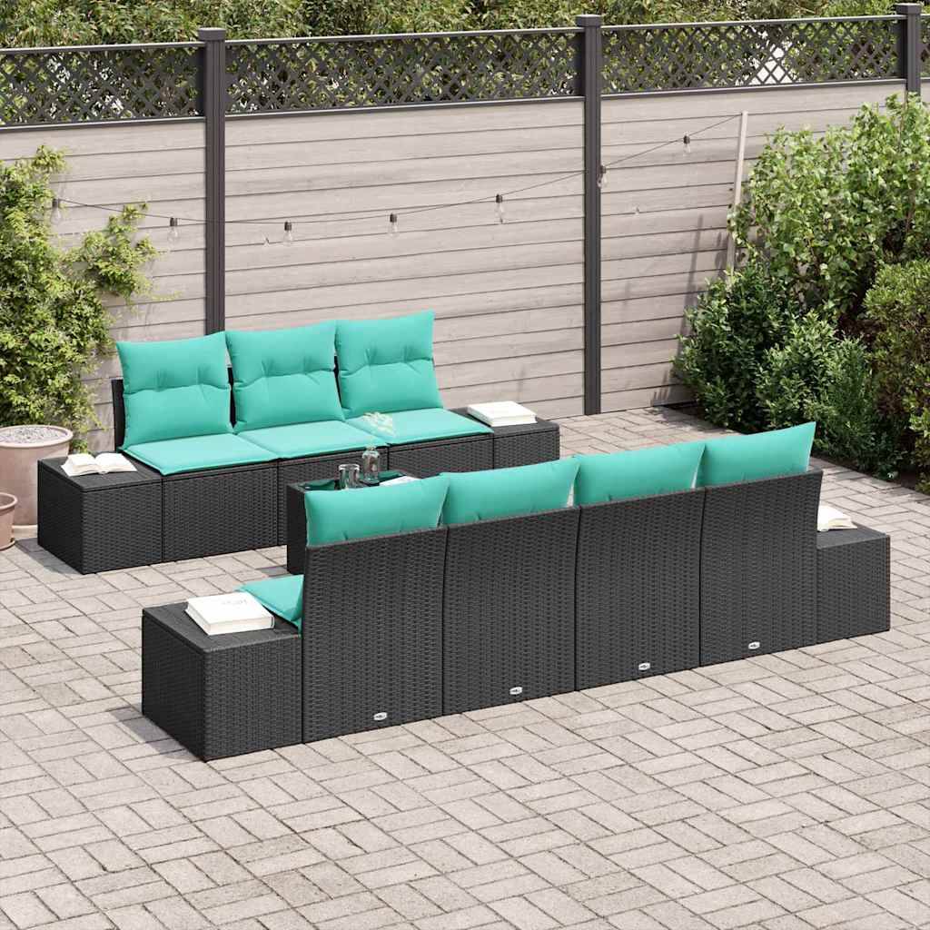 Gartenmöbelset für die Terrasse mit schwarzen Polyrattan-Ecksofas und türkisfarbenen Kissen, angeordnet um einen niedrigen Tisch auf einer gepflasterten Terrasse.