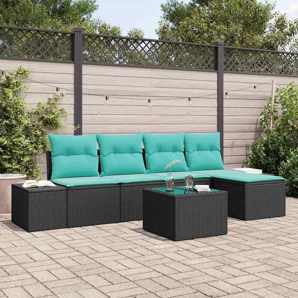 Gartenmöbelset für die Terrasse mit schwarzem Rattan-Sofa und Hocker, türkisfarbenen Kissen und passendem Couchtisch auf einer gepflasterten Hinterhof-Terrasse.