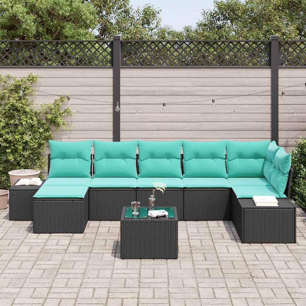 Außenterrasse mit schwarzem Polyrattan-Ecksofa und türkisfarbenen Kissen um einen niedrigen Couchtisch auf einer gepflasterten Hof-Terrasse.