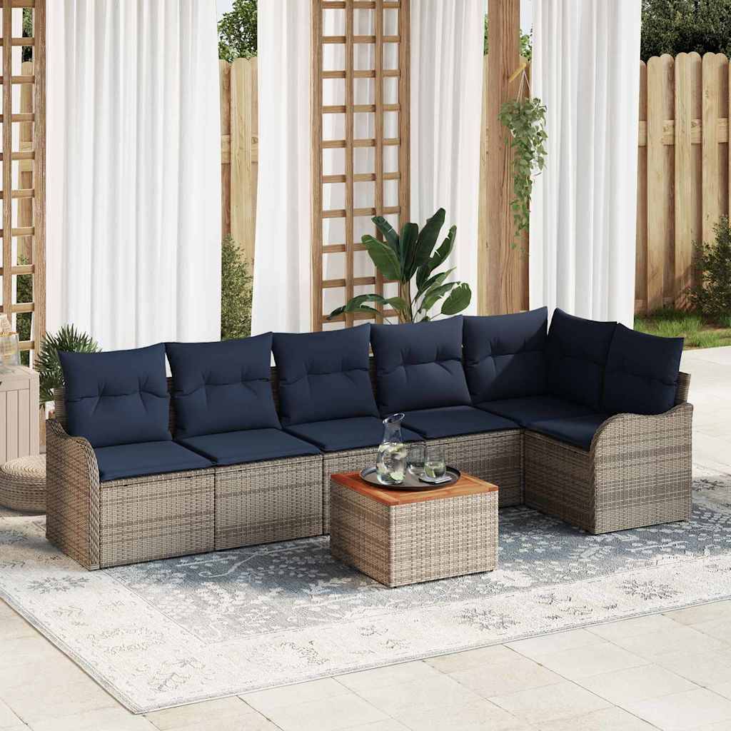 Outdoor-Wickel-Ecksofa-Set mit dunkelblauem Kissen und passendem Hocker auf einem gemusterten Teppich in einer Patio-Gartenanlage.