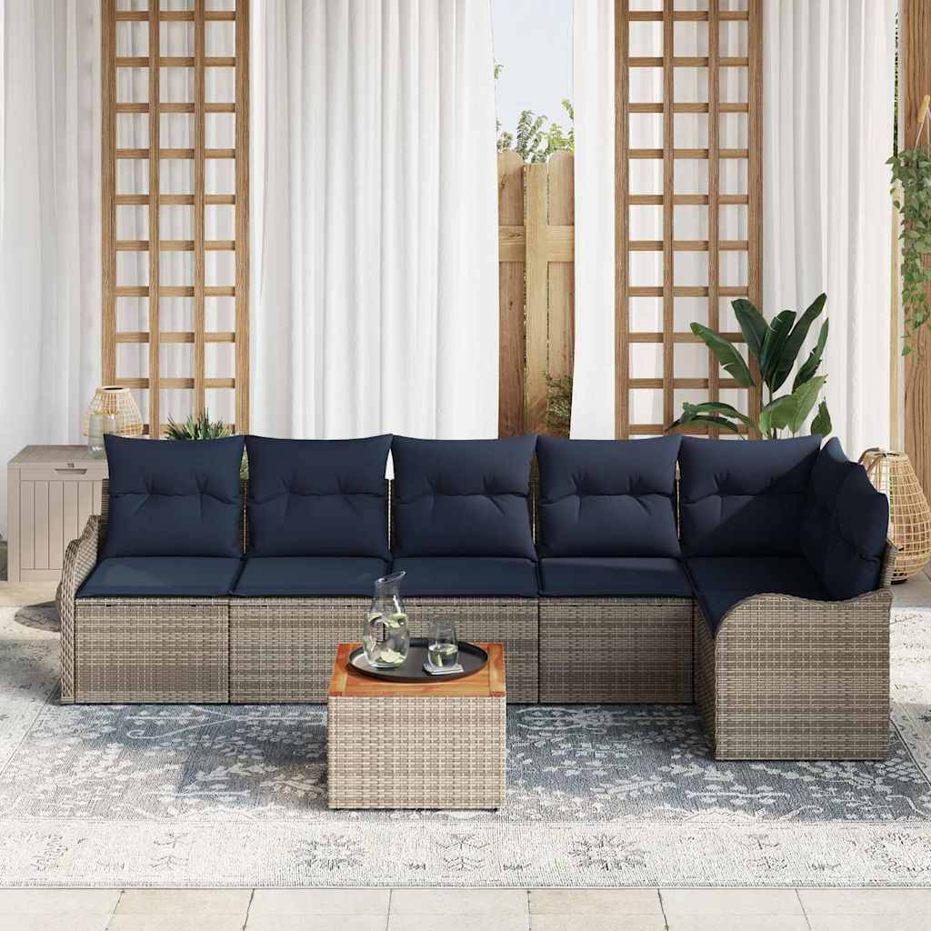 Outdoor-Rattanecksofa mit dunkelmarineblauen Kissen und passendem quadratischem Couchtisch auf einem gemusterten Teppich in einer Terrassensituation.