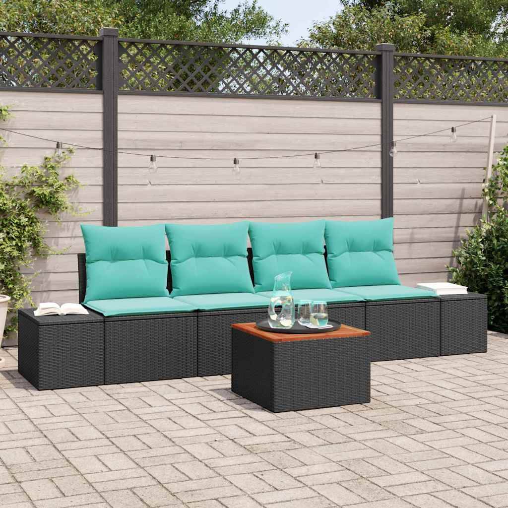 Gartenmöbel-Set mit Sitzkissen in Türkis, schwarzem Rattan-Sofa und passendem Couchtisch auf einer gepflasterten Terrasse neben einem Holzzaun.
