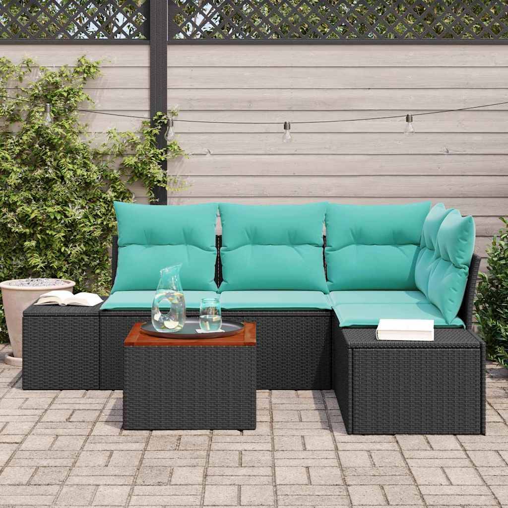 Outdoor-Terrassenmöbel-Set mit türkisfarbenen Kissen, schwarzem Rattansofa und Ottomanen sowie einem kleinen Tisch auf einer gepflasterten Terrasse.
