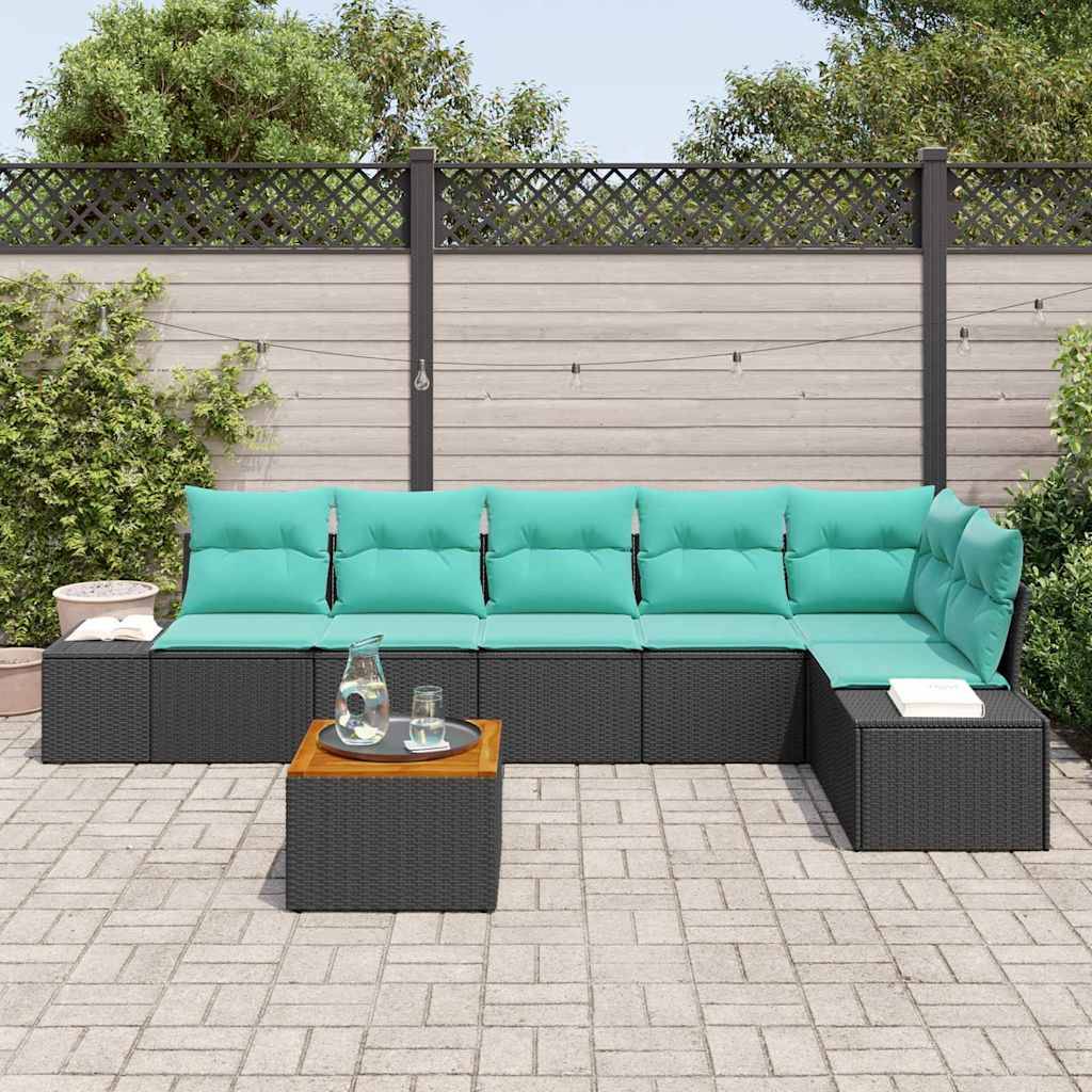Outdoor-Sitzbereich auf der Terrasse mit dunklem Rattan-Ecksofa, türkisfarbenen Kissen und einem kleinen Couchtisch auf einer gepflasterten Terrasse neben einem eingezäunten Garten.