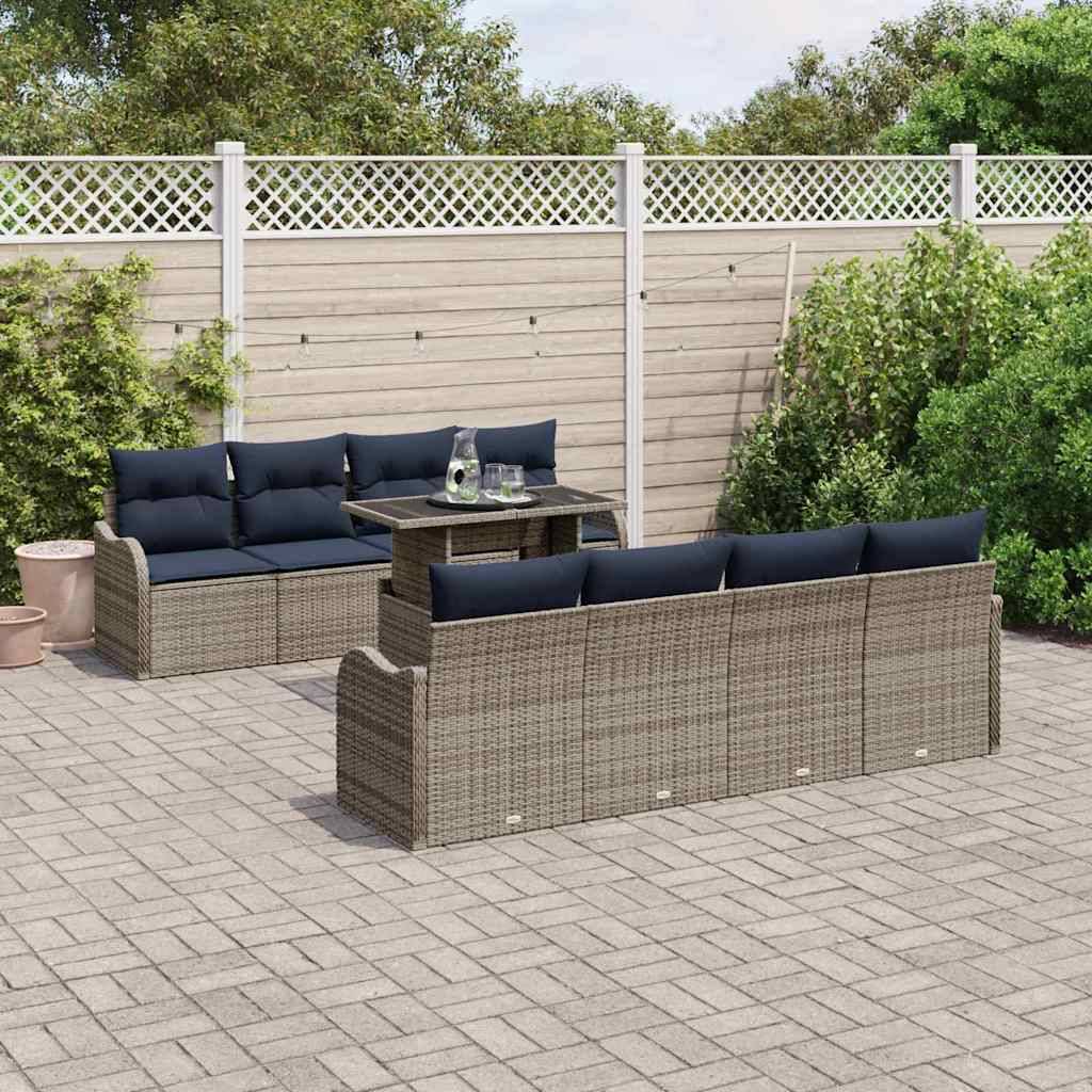 Outdoor-Terrassenbesteck mit Rattansofa, zwei Bänken und einem kleinen Tisch auf einer gepflasterten Terrasse neben einem Gartenzaun.