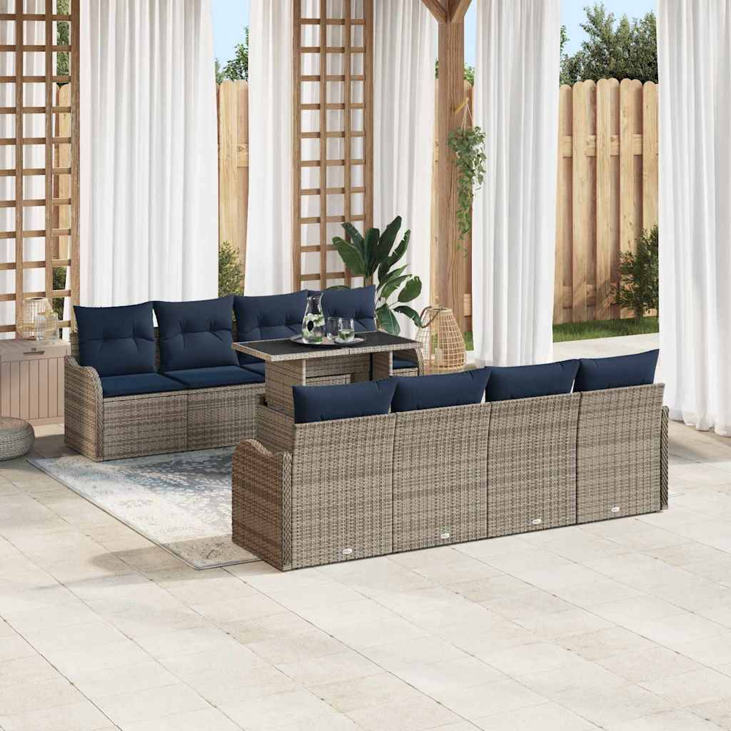 Gartenbereich mit Sitzmöbeln bestehend aus zwei geflochtenen Rattansofas mit marineblauen Kissen und einem passenden Couchtisch unter einer Pergola mit weißen Vorhängen.