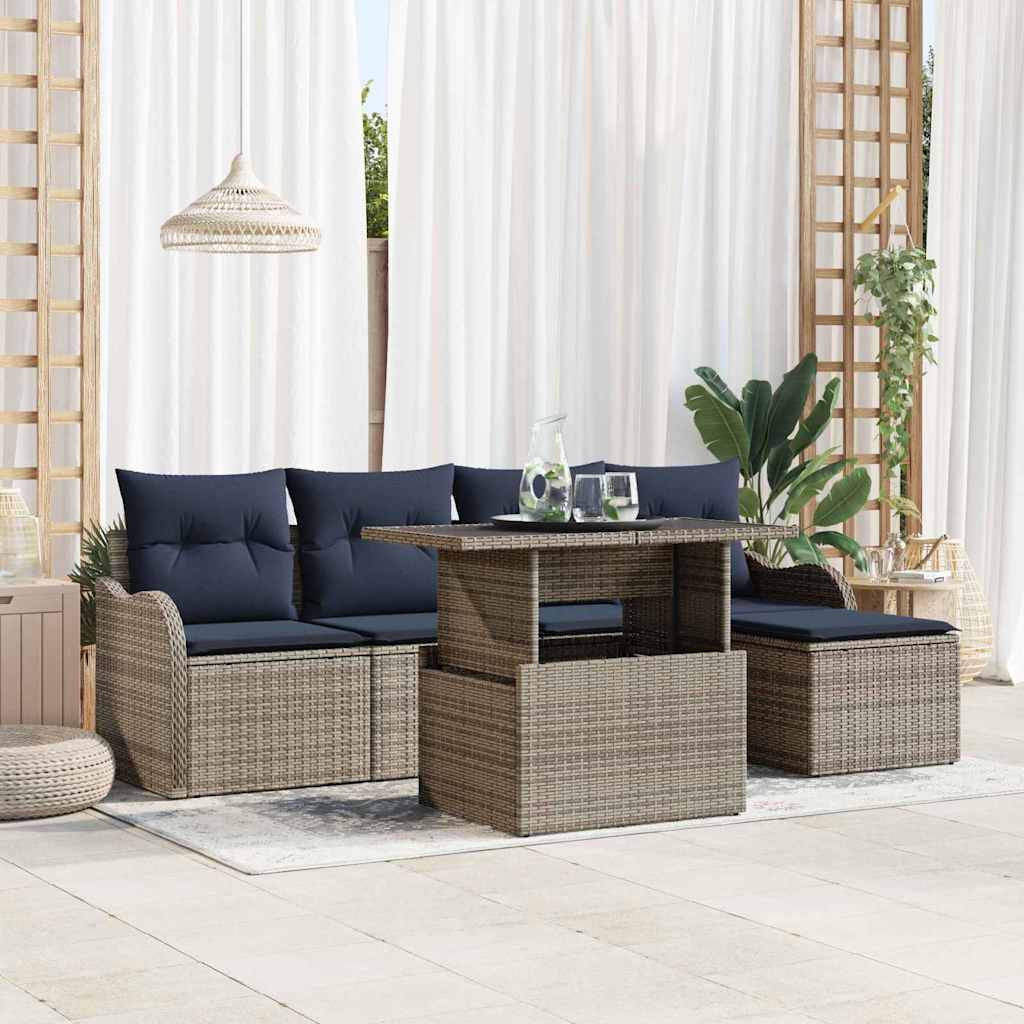 Terrassensitzgruppe mit Rattansofa, Ottomanen und Tisch mit marineblauen Kissen in einem hellen Außenlounge-Bereich.