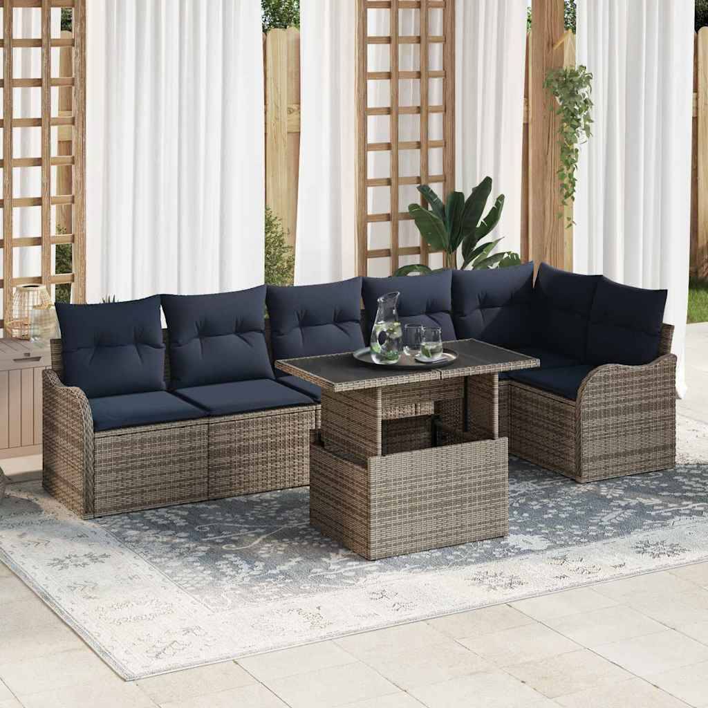 Outdoor-Sektionalsofa aus Rattan mit dunkelblauem Kissen, quadratischem Couchtisch und passendem Beistellhocker auf einem gemusterten Teppich.