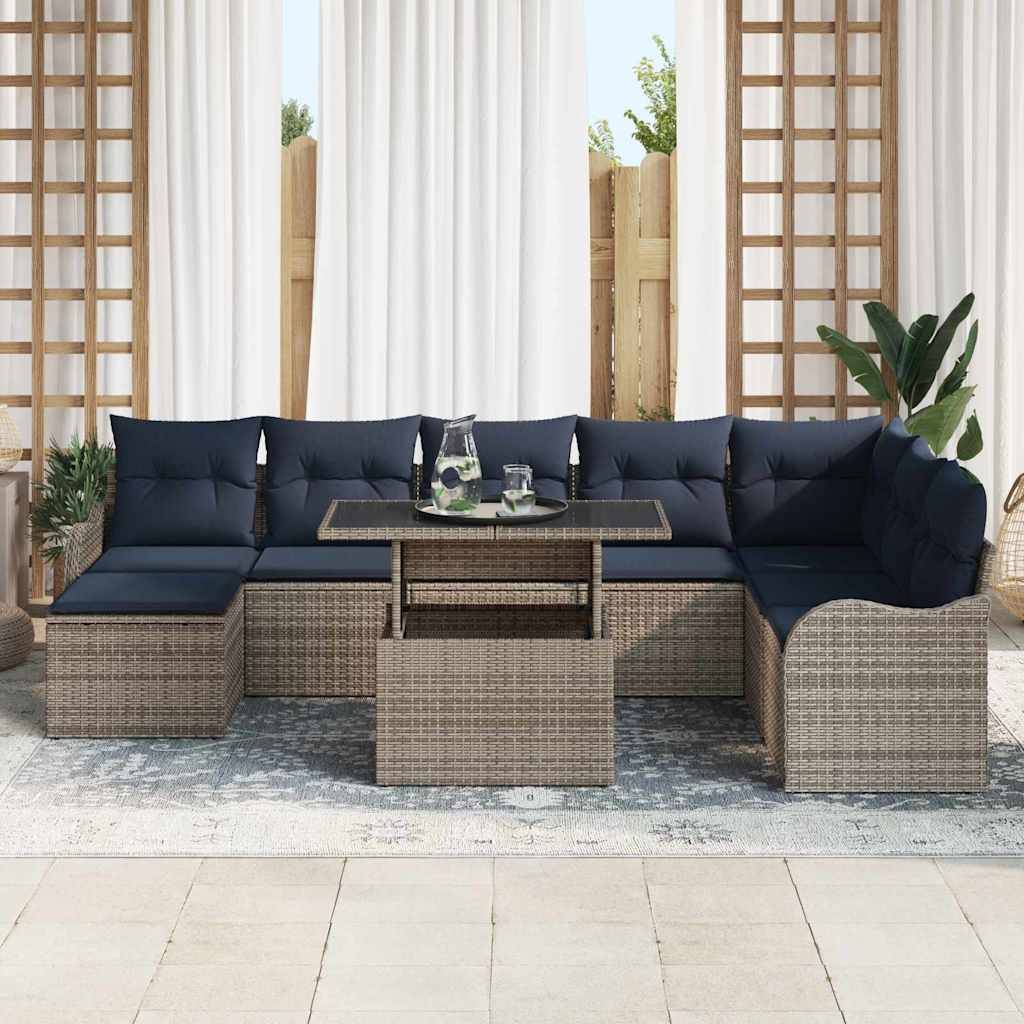 Outdoor-Rattansektionalsofa mit marineblauen Kissen und einem Glastisch auf einer Terrasse, mit Pflanzen und weißen Vorhängen dahinter.