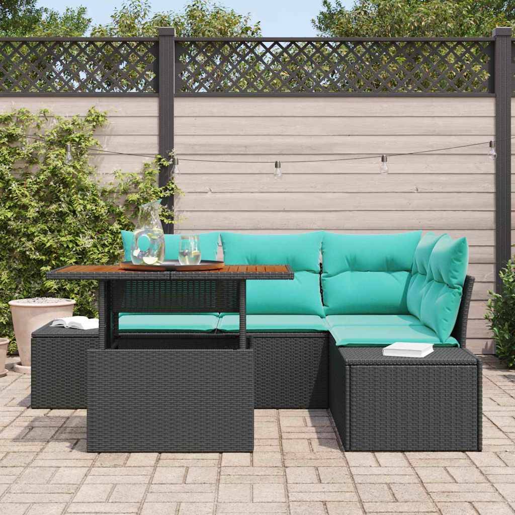 Outdoor-Terrassenmöbelset mit türkisfarbenen Kissen, schwarzen Rattanmöbeln und einem kleinen Tisch auf einer gepflasterten Terrasse neben einem Zaun und Grünflächen.
