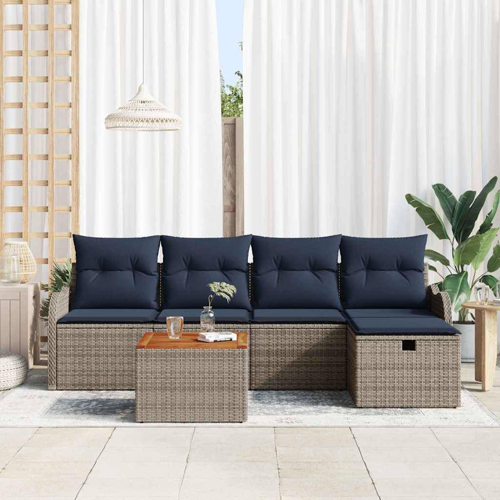 Gartenbereichs-Sitzmöbel-Set mit dunkelblauem gepolstertem Sektional-Sofa, geflochtenen Wicker-Sockeln, passendem Couchtisch und Pflanzen auf einer hellen gekachelten Terrasse.