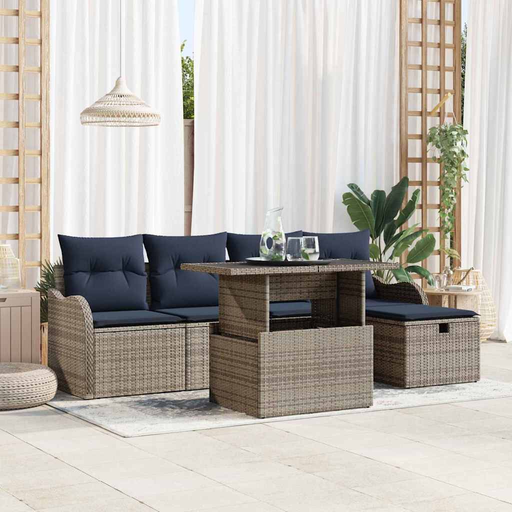 Outdoor-Sitzmöbel-Set für die Terrasse mit Rattansofa, Stühlen und Tisch, ausgestattet mit dunkelblauem Polster, Pflanzen und weißen Vorhängen in einem hellen Wintergarten.
