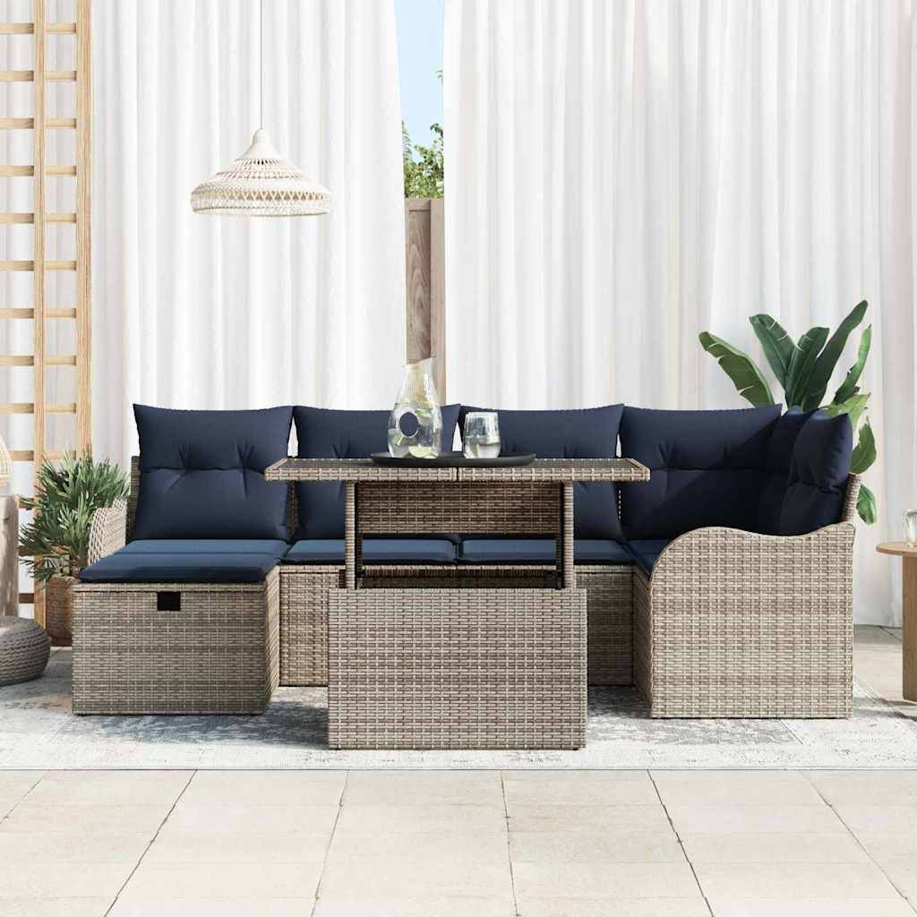Gartenmöbel-Set für die Terrasse mit Polyrattan-Ecksofa, marineblauen Polstern, Couchtisch und hängender Pendelleuchte in einem hellen überdachten Bereich.