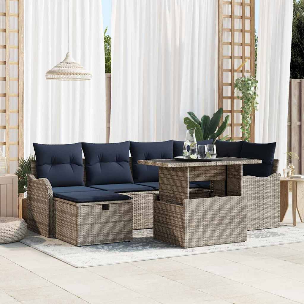 Outdoor-Rattaneckgarnitur mit marineblauen Kissen und passendem Tisch auf einer Terrasse, gestylt mit Pflanzen und Vorhängen.