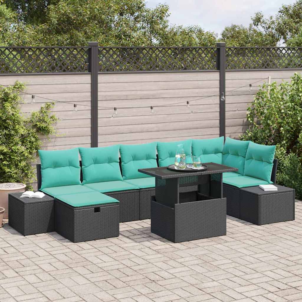 Outdoor-Terrassensitzgruppe mit türkisen Kissen, schwarzen Rattansofa, Ottomanen und einem quadratischen Couchtisch auf einer gepflasterten Terrasse neben einem Zaun und Grünflächen.