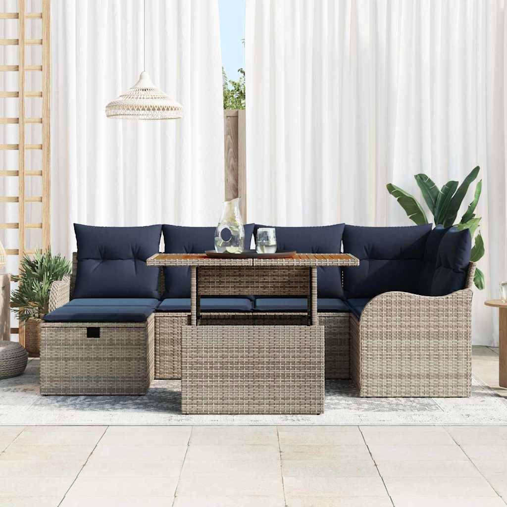 Outdoor-Sitzmöbel-Set mit dunkelblau Kissen, Rattan-Eckstühle und passendem Couchtisch vor weißen Vorhängen.