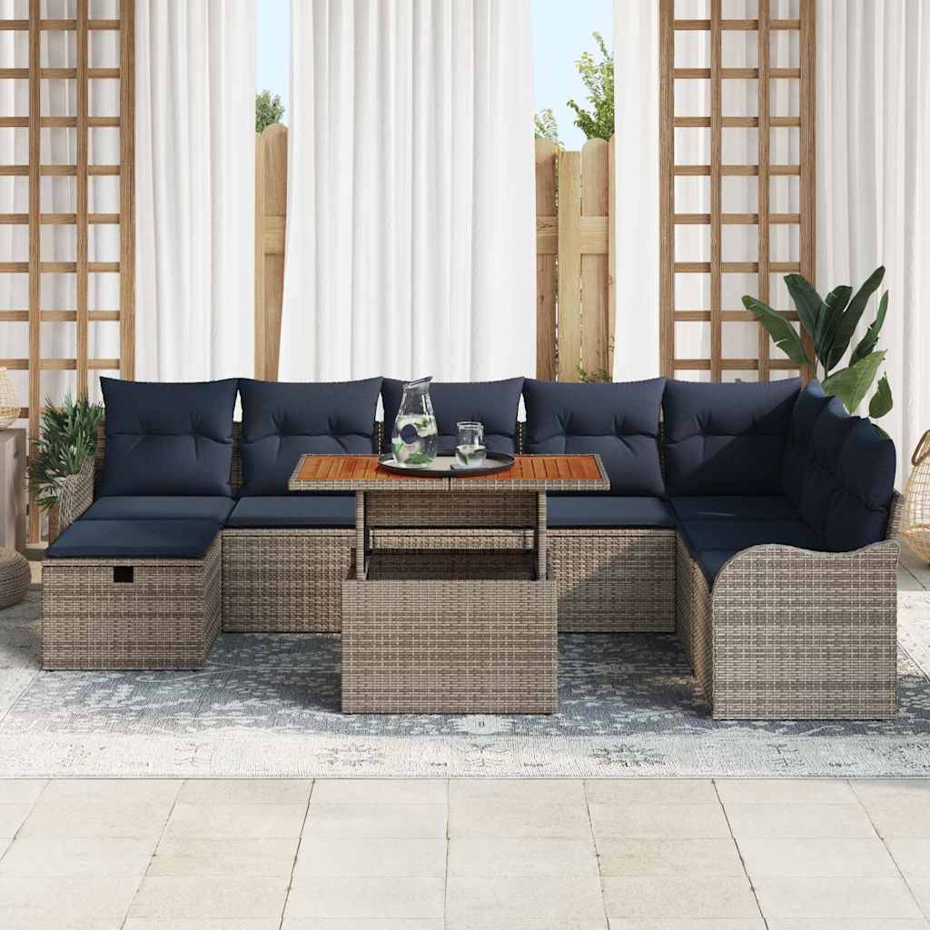 Outdoor-Rattangarnitur mit dunkelblauen Kissen und kleinem Couchtisch, auf einem Teppich in einer hellen Terrassenumgebung angeordnet.