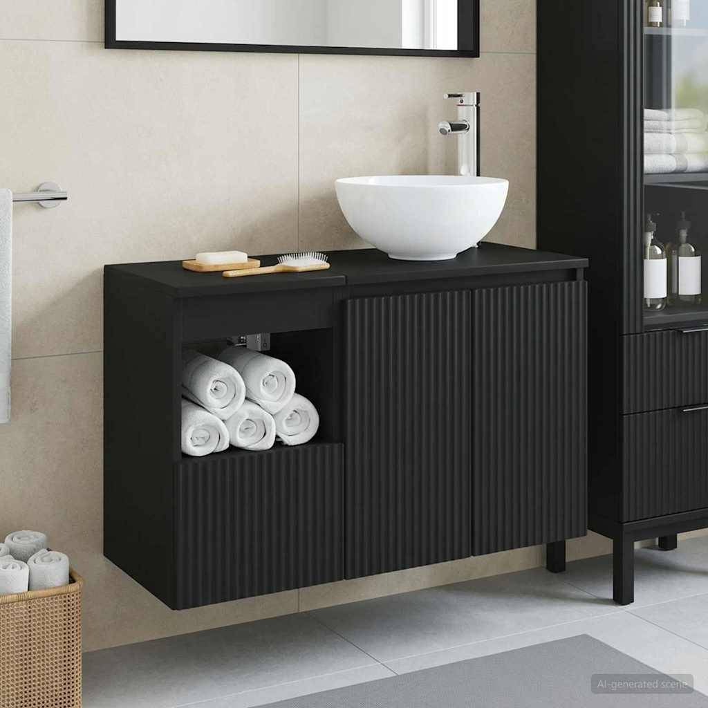 Modernes Badezimmer-Waschbecken mit weißem Aufsatzwaschbecken auf schwarzem Unterschrank, offenes Regal mit aufgerollten Handtüchern und kannelierte Türen; Handtuchkorb daneben.