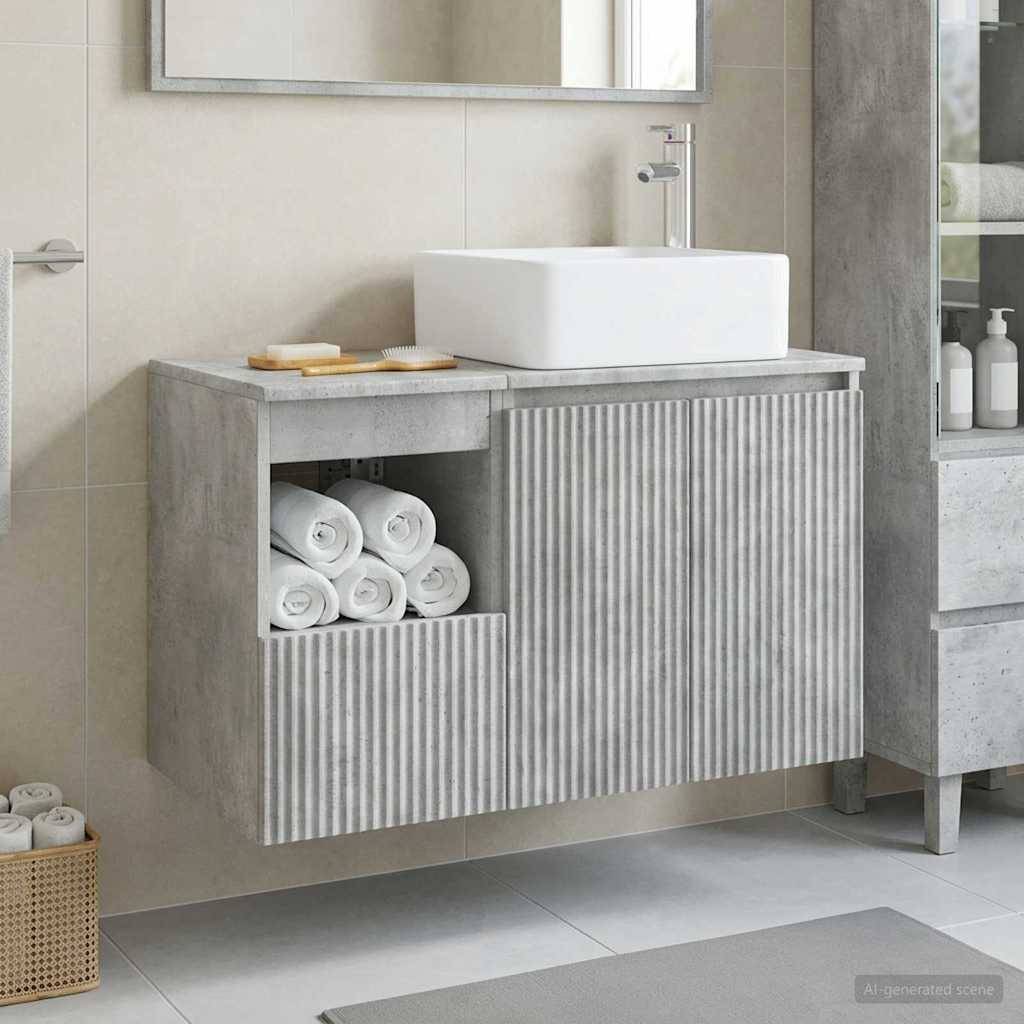 Modernes Badezimmermöbel mit weißem Aufsatzwaschbecken und Armatur, Schrank mit Betonoptik, offenes Handtuchwagen und gerillte Frontplatte.