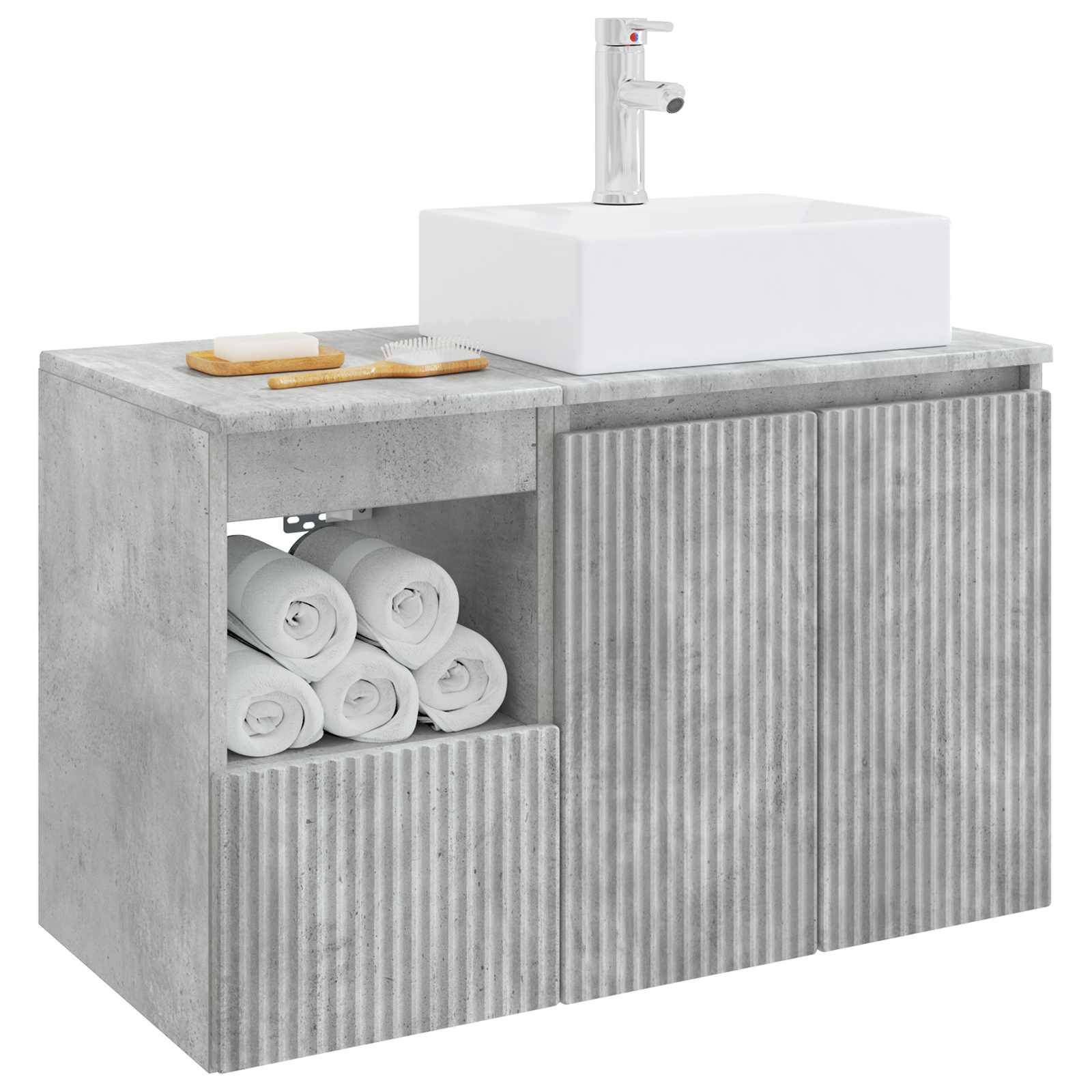 Modernes Badezimmer-Waschtisch mit weißem Waschbecken und Armatur, Schrank in Betonoptik, gerillte Türen, offenes Handtuchwregal und Arbeitsplatte mit Seifenschale und Bürste.