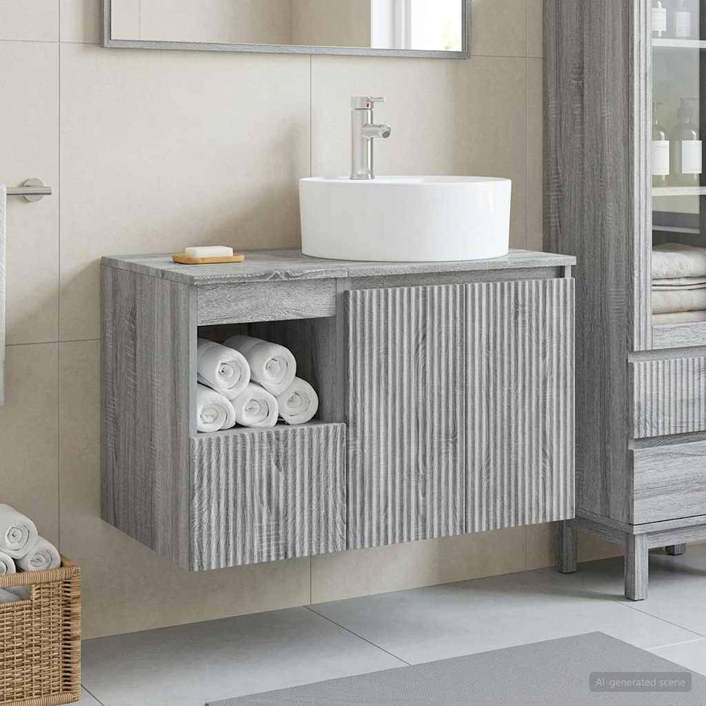 Graues geripptes wandmontiertes Badezimmer-Waschtisch mit weißem Aufsatzwaschbecken, offenes Handtuechregal und gefaltete Handtücher unter einem Spiegel.