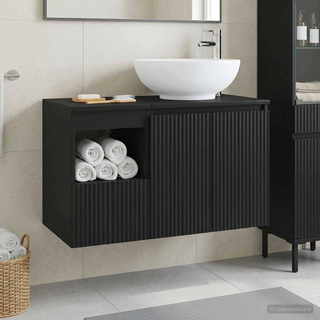Modernes schwarz wandmontiertes Badezimmerschrank mit gerillten Schranktüren, offenem Handtuchtablar und weißem Aufsatzwaschbecken vor hellverkachelter Wand.