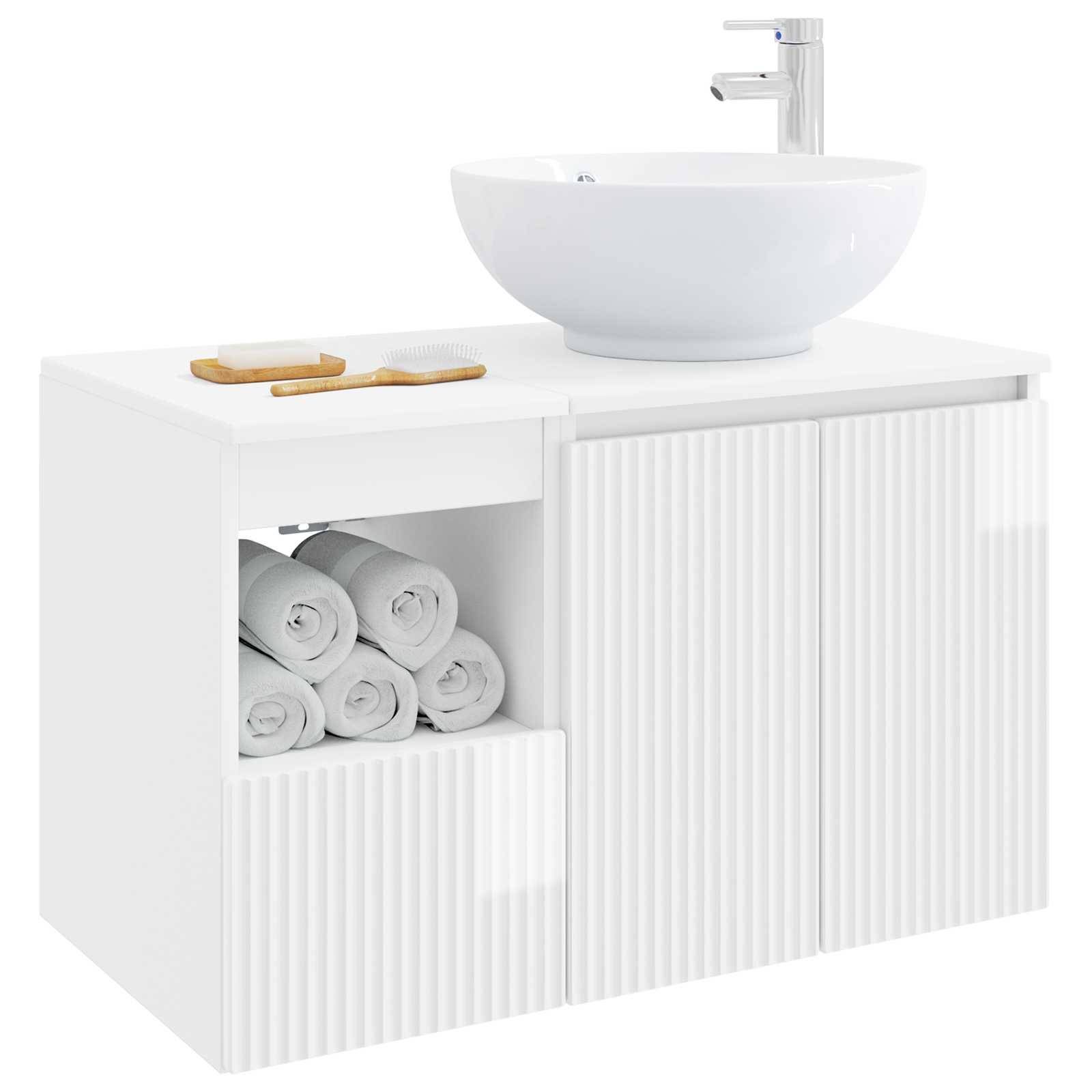 Weiße Badezimmervantity mit rundem Waschbecken und Armatur, offenes Regal mit aufgerollten Handtüchern und einer Schranktür mit Lamellenmuster.