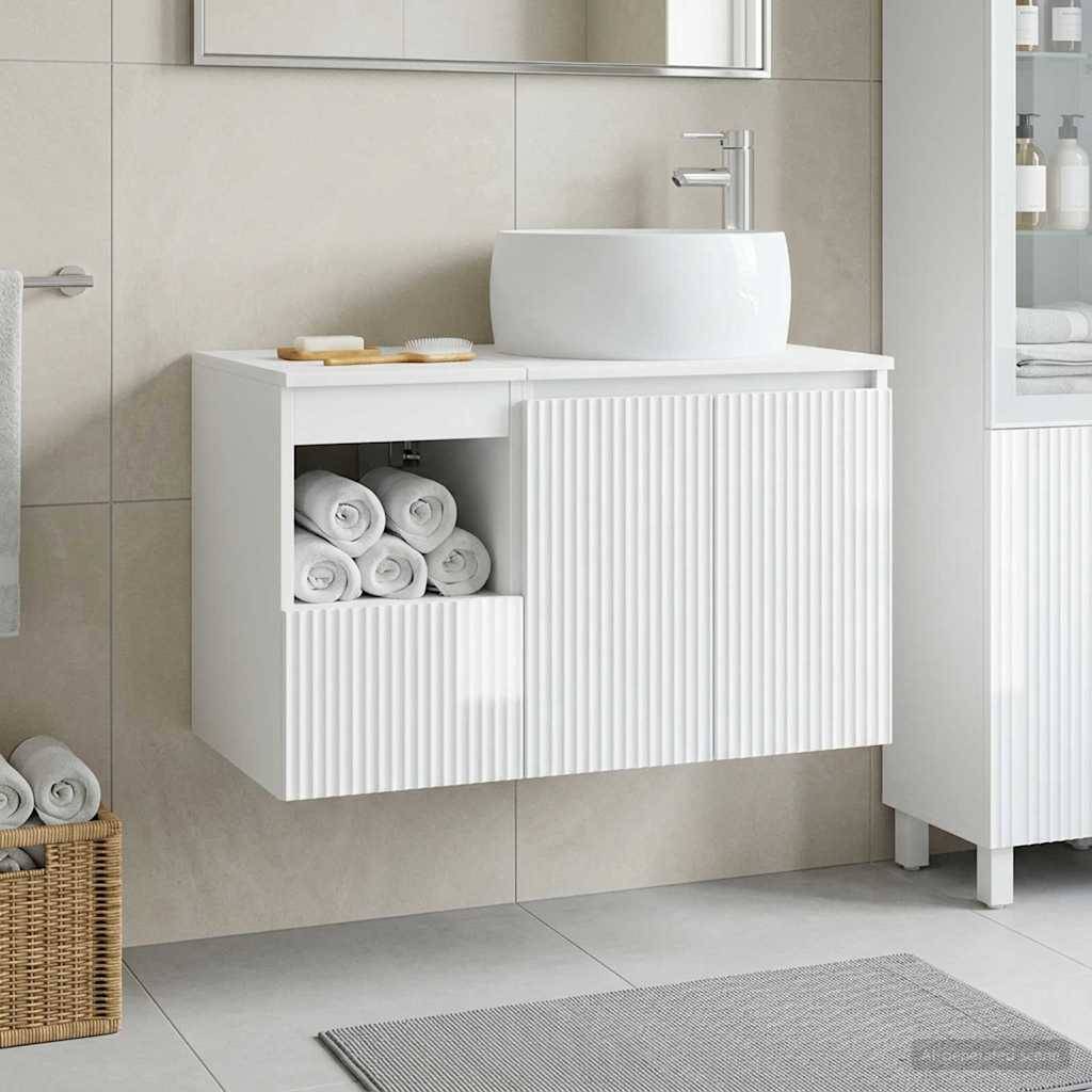 Wandmontiertes weißes Badezimmer-Waschtischset mit rundem Waschbecken und Armatur, gerillten Schranktüren, offenem Handtuch-Fach und einem Weide-Handtuchkorb auf dem Boden.