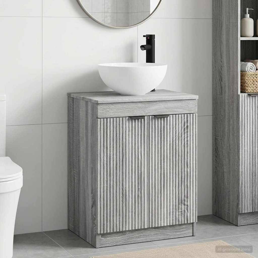 Modernes Badezimmer-Waschtisch mit weißem Aufsatzwaschbecken und schwarzem Wasserhahn, vor Hintergrund von hell gekachelten Wänden und grauer Holzschränke.