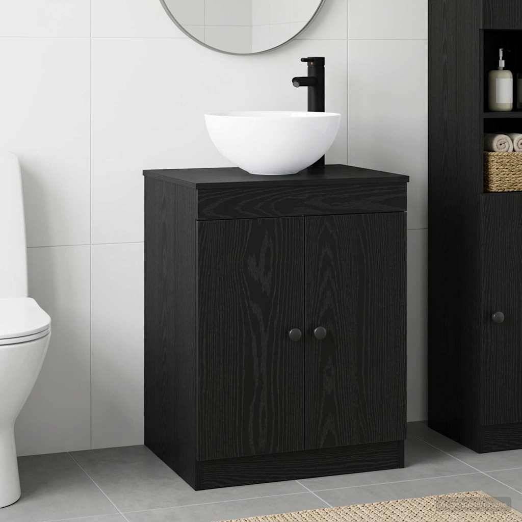 Schwarzes Holz Badezimmer Waschtisch mit weißem Aufsatzwaschbecken und mattschwarzem Wasserhahn neben einer Toilette im gefliesten Badezimmer