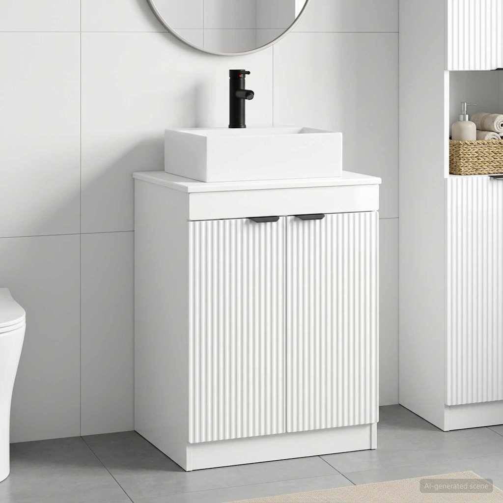 Minimalistische weiße Badezimmervandage mit gerillten Schrankktüren, rechteckigem Waschbecken, schwarzem Wasserhahn und rundem Spiegel an der gefliesten Wand.