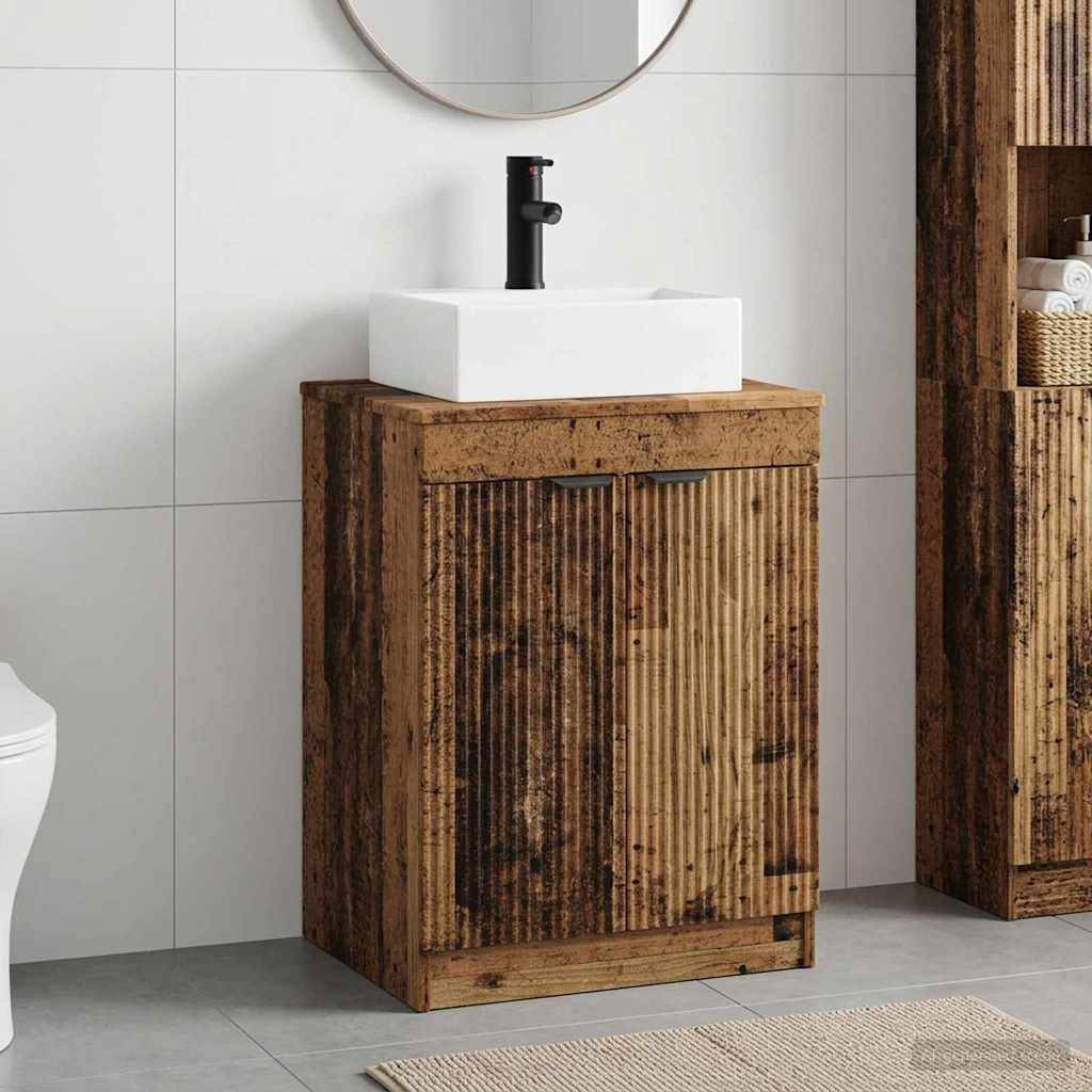 Holzwaschbeckenunterschrank mit weißem Aufsatzbecken und schwarzem Wasserhahn vor einer gefliesten Wand, mit einem runden Spiegel darüber.