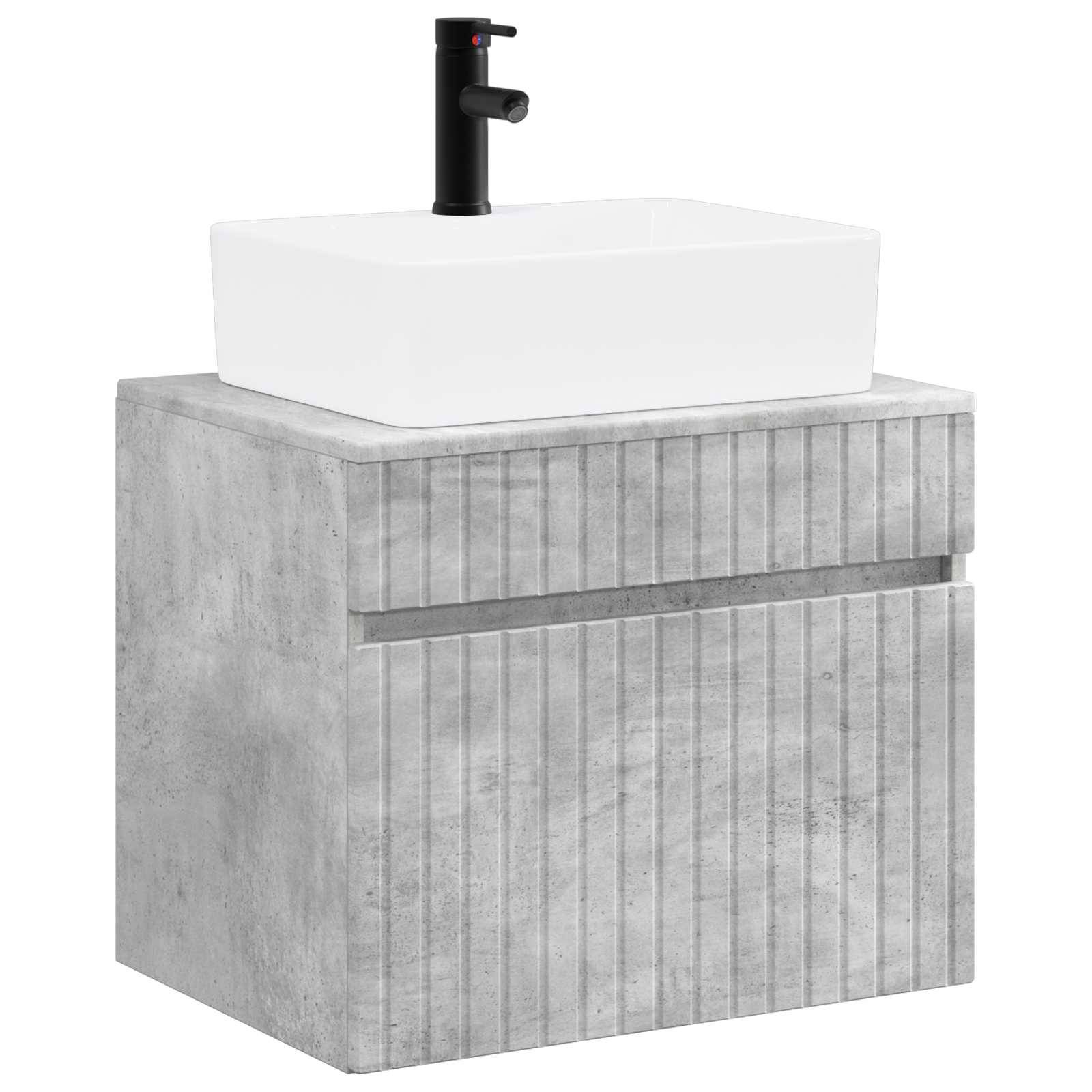 Modernes Badezimmer-Waschtisch mit einem weißen rechteckigen Waschbecken und schwarzem Wasserhahn auf einem grauen Betonschrank mit vertikal gerippten Frontpaneelen.