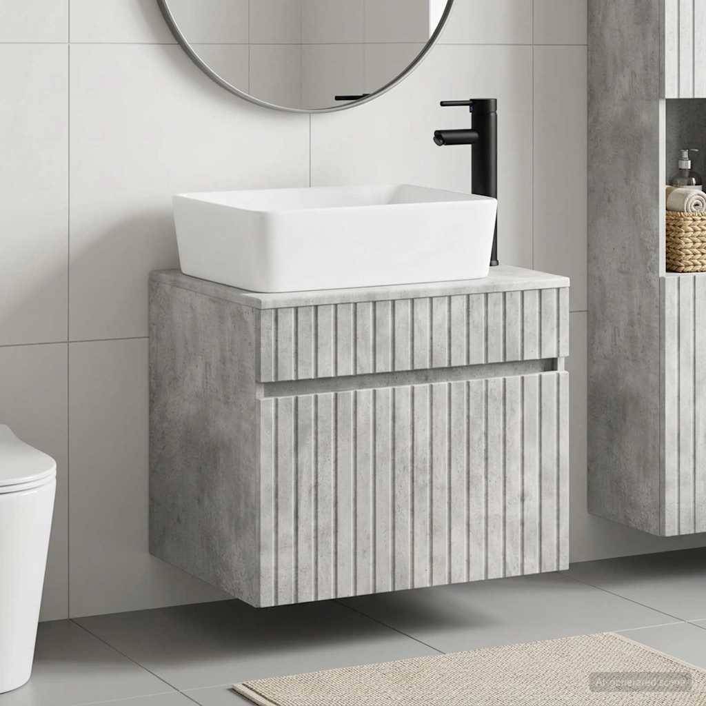 Modernes Badezimmer-Waschtisch mit weißem Aufsatzwaschbecken, schwarzem Wasserhahn und grauem strukturiertem Unterschrank unter einem runden Spiegel.