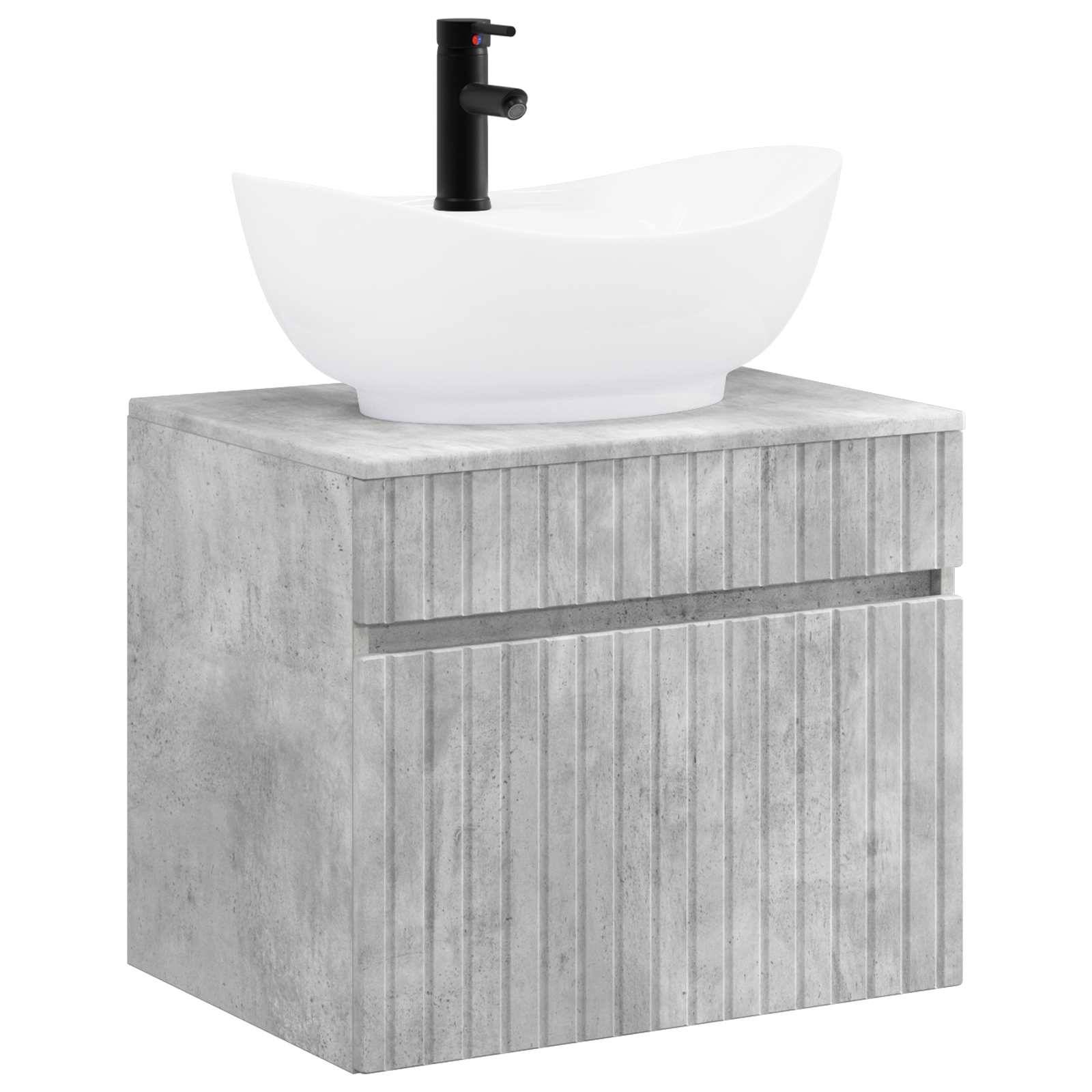 Modernes Badezimmerwaschtisch mit Betonoptik-Schrank, weißem Aufsatzwaschbecken und schwarzem Wasserhahn auf schlicht weißem Hintergrund.