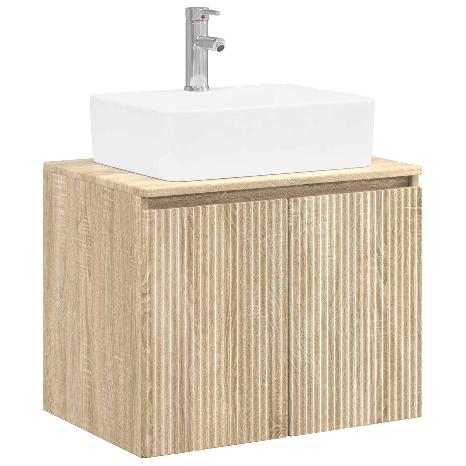 Weißes quadratisches Waschtischbecken mit verchromtem Wasserhahn auf einem Waschtischschrank aus hellem Holz.