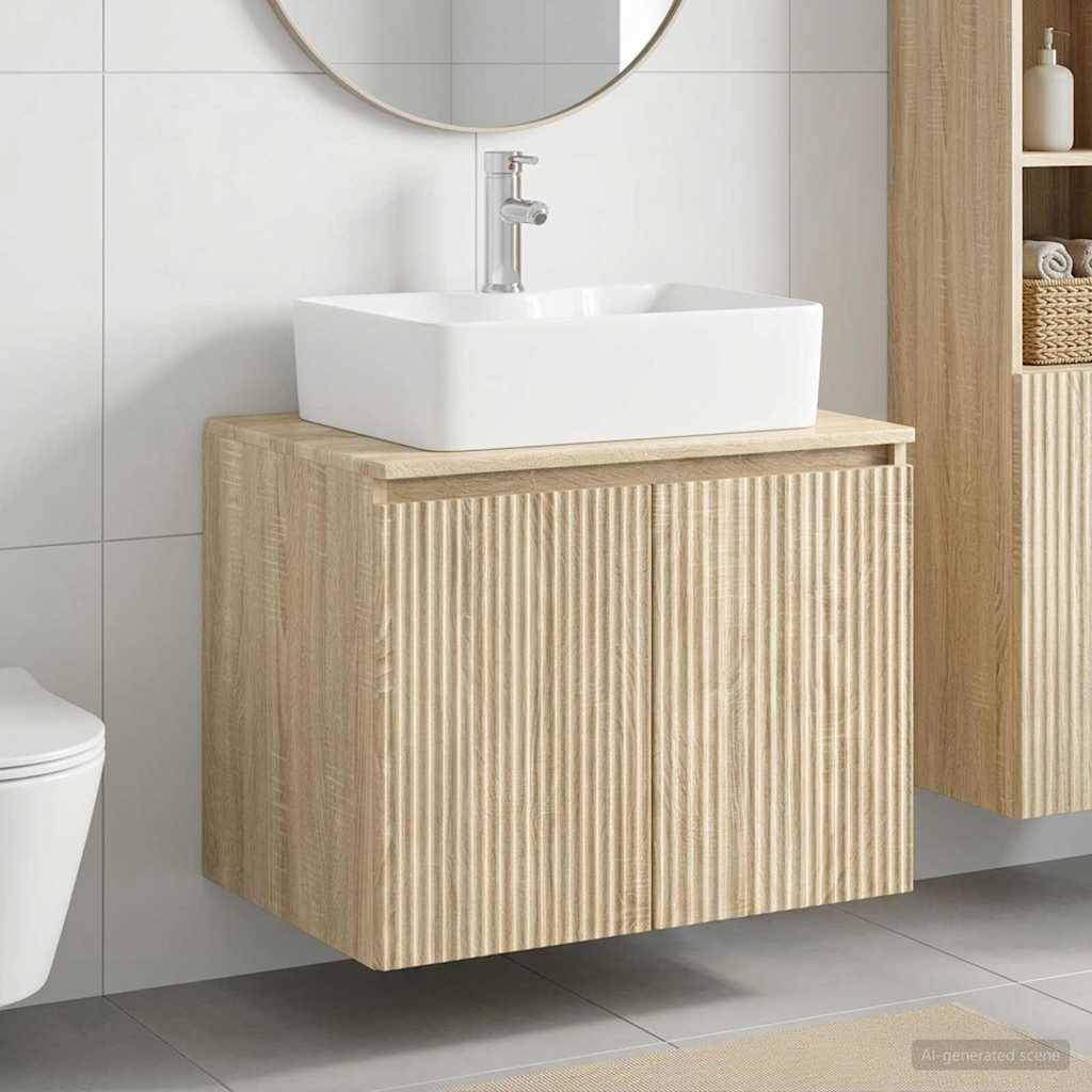 Modernes Badezimmer-Waschtisch mit einem weißen Aufsatzbecken auf einem hellen Holzschrank mit vertikalen Rillen, neben einem Spiegel und einer Toilette.