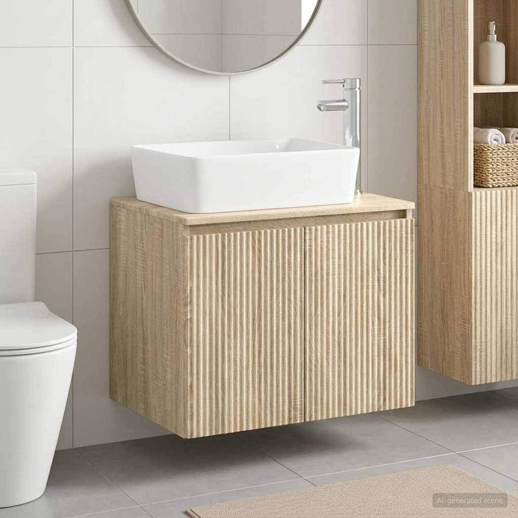 Modernes Badezimmer mit an der Wand montiertem Holz-Waschtisch und weißem Aufsatzwaschbecken neben einer Toilette, in einem hell gefliesten Innenraum.