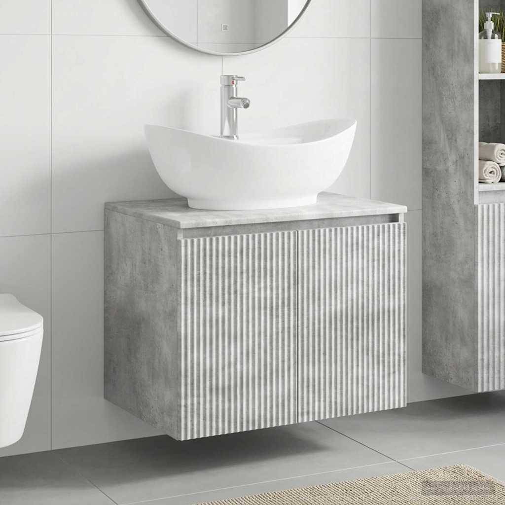 Modernes Badezimmer-Waschtisch mit weißem Aufsatzwaschbecken und rundem Spiegel, auf einem grau gestreiften Schrank neben gefliesten Wänden und Boden.