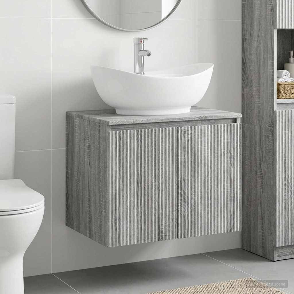 Modernes Badezimmer mit einem wandmontiertem grauen Waschtisch und weißem Aufsatzwaschbecken, gezeigt neben einer Toilette und gekachelter Wand.