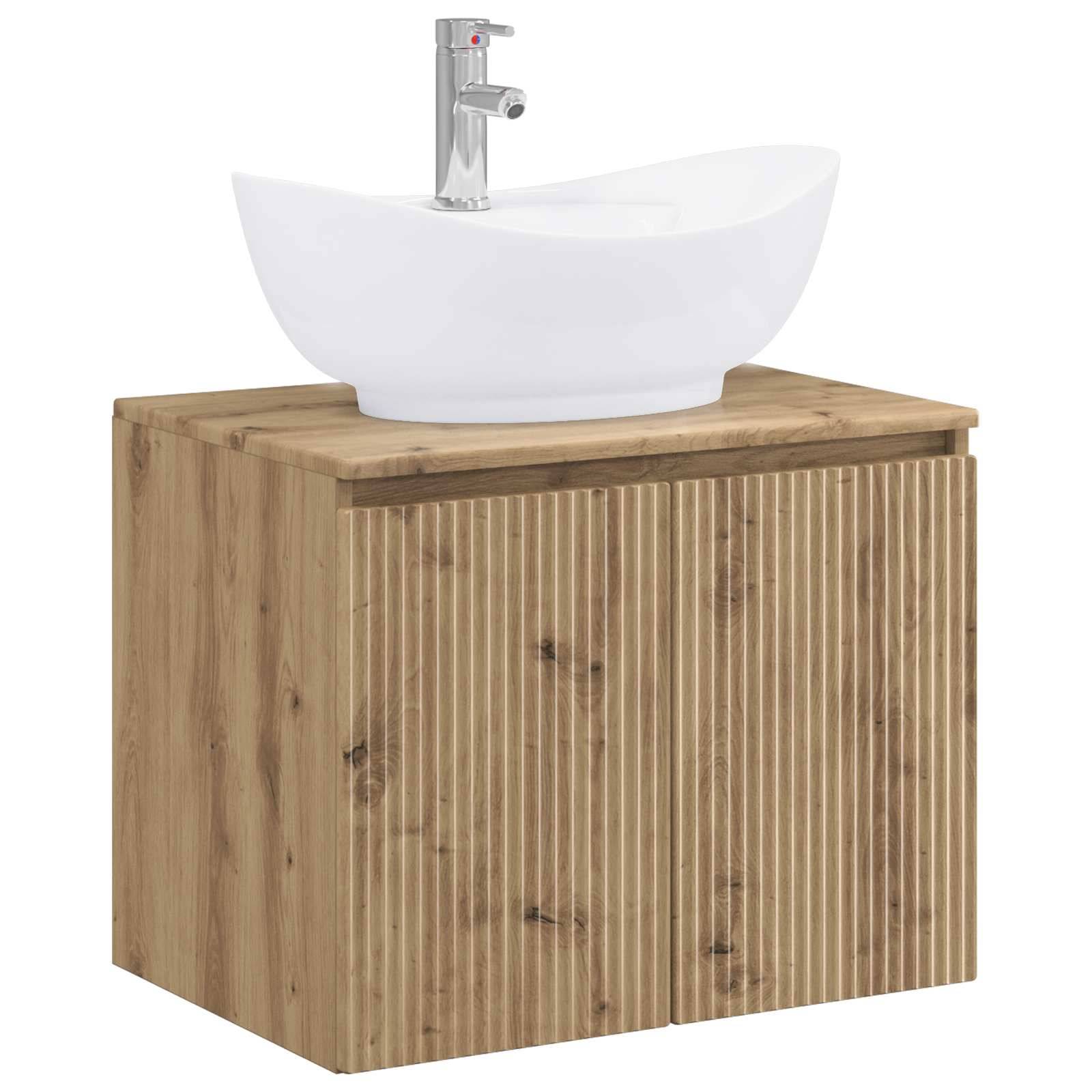 Weißes Keramik-Waschbecken auf einem Badezimmer-Waschtischkasten aus Holz mit vertikal lamellierter Front und verchromtem Wasserhahn.