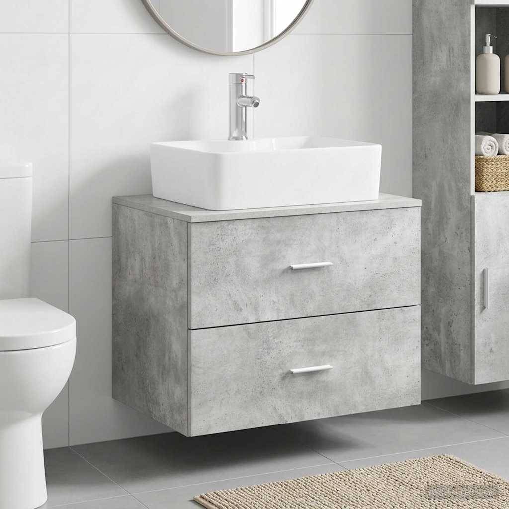 Modernes Badezimmer-Waschtisch mit weißem Aufsatzwaschbecken über einem Doppelschubladenschrank im Betonlook, neben einer Toilette und einem Regalsystem zur Aufbewahrung.