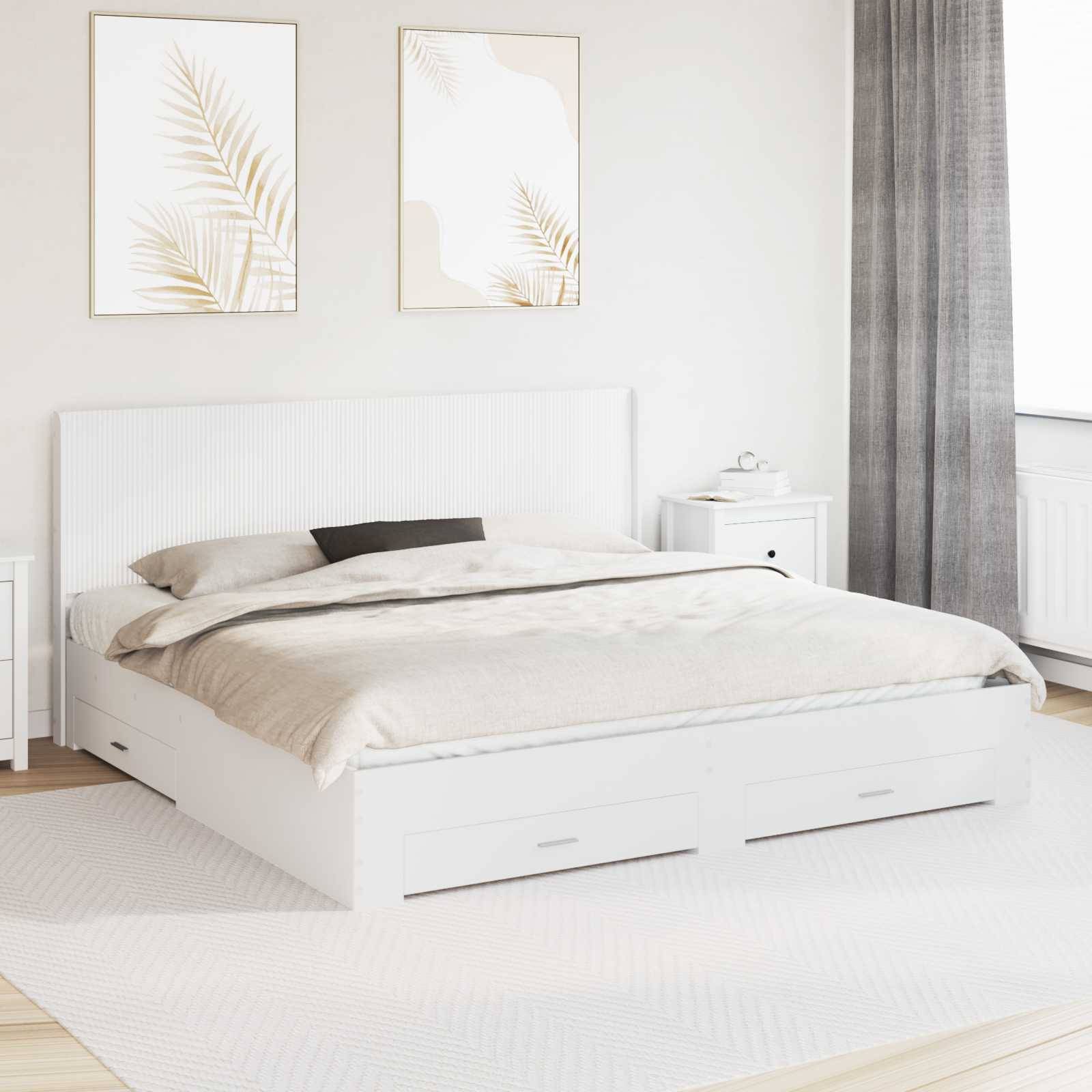 Helles, minimalistisches Schlafzimmer mit einem weißen Bett, beigefarbener Bettwäsche, gerahmten Blattdrucken, einem kleinen Nachttisch und grauen Vorhängen.