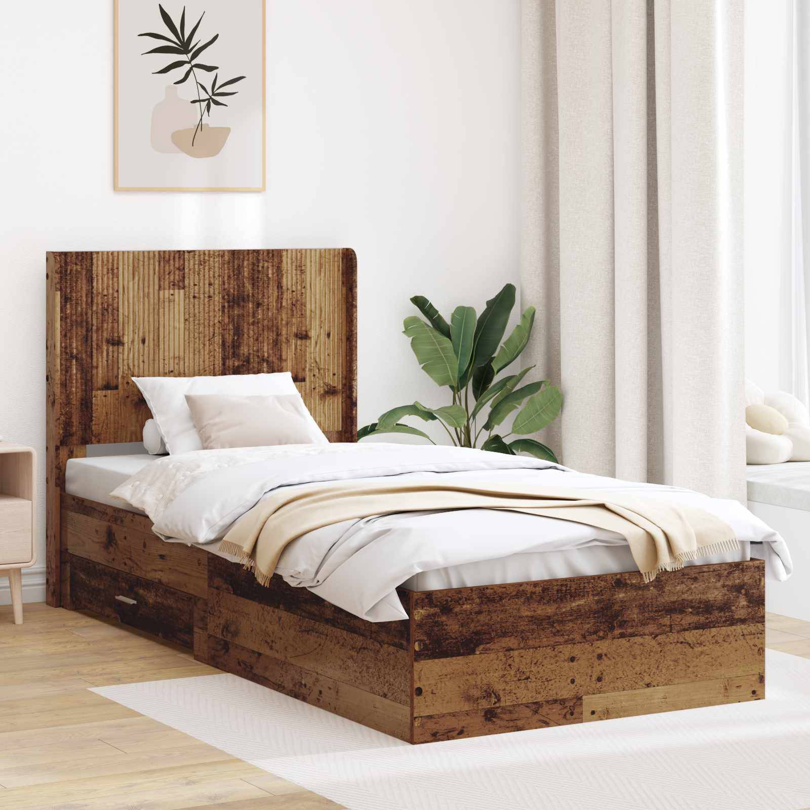 Holzbett mit eingebauten Schubladen in einem hellen Schlafzimmer, bezogen mit weißer Bettwäsche, mit einer Pflanze und Wandkunst daneben.